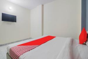 ein weißes Bett mit einer roten Decke darüber in der Unterkunft Hotel O Grand Residency in Neu-Delhi