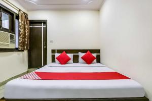 ein Schlafzimmer mit einem großen Bett mit roten Kissen in der Unterkunft Hotel O Grand Residency in Neu-Delhi