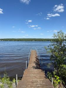 a wooden dock sticking out into a large body of water at Havre du lac magog in Sainte-Catherine-de-Hatley +32 photos