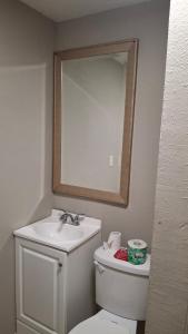 Un baño con lavabo, inodoro y espejo. en Skyline Motel, en Las Vegas