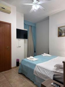 Cette chambre comprend deux lits et un ventilateur de plafond. dans l'établissement Guesthouse Alex II, à Rome