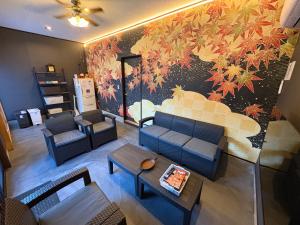 a living room with a couch and a wall mural at Guesthouse すえ in Mashizume