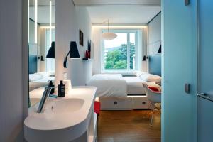 sypialnia z łóżkiem, umywalką i lustrem w obiekcie citizenM New York Bowery w Nowym Jorku +31 zdjęć