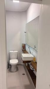 a bathroom with a white toilet and a sink at Palais House in São Vicente +25 photos