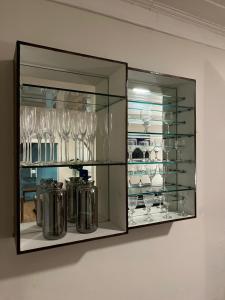 une vitrine en verre contenant des verres et de la vaisselle dans l'établissement Palais House, à São Vicente