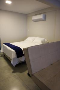 a bedroom with a white bed with a blue blanket at Catamarã Pé na Areia in Angra dos Reis +41 photos