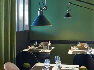 un ristorante con due tavoli, sedie e luci di Novotel Paris Gare De Lyon a Parigi