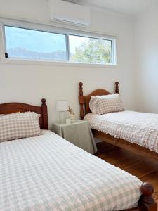 ein Schlafzimmer mit zwei Betten und einem Fenster in der Unterkunft The Kandos Nook- Adventure, Wine & Country Charm in Kandos