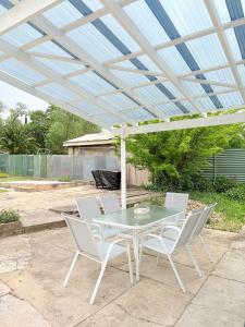 eine Terrasse mit Tisch und Stühlen unter einer Pergola in der Unterkunft The Kandos Nook- Adventure, Wine & Country Charm in Kandos + 6 Fotos