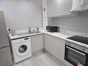 a kitchen with a washing machine and a sink at Penge lovely studio in Sydenham