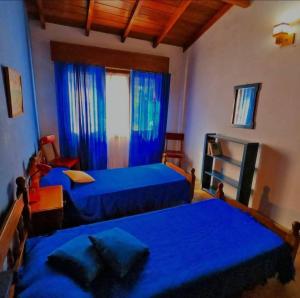 ein Schlafzimmer mit zwei Betten und einem Fenster mit blauen Laken in der Unterkunft Casa en Alquiler San Bernardo in San Bernardo