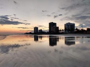 - une vue sur une plage avec des bâtiments en arrière-plan dans l'établissement Casa Pé na Areia Centro de Mongaguá, à Mongaguá