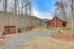 a cabin in the woods next to a dirt road at Greenbrier River On-Site! Modern-Rustic Log Cabin in Marlinton
