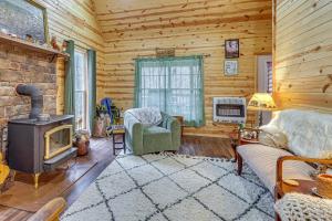 a living room with a woodburning stove in a cabin at Greenbrier River On-Site! Modern-Rustic Log Cabin in Marlinton