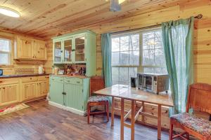 a kitchen with a table and a window in a cabin at Greenbrier River On-Site! Modern-Rustic Log Cabin in Marlinton