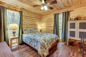 a bedroom with a bed and a ceiling fan at Greenbrier River On-Site! Modern-Rustic Log Cabin in Marlinton