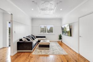 ein Wohnzimmer mit Sofa und Tisch in der Unterkunft Botanic Breeze! Opposite Queens Park! in Toowoomba