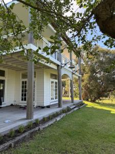 Un porche de una casa blanca con columnas. en French Island Hill House, 