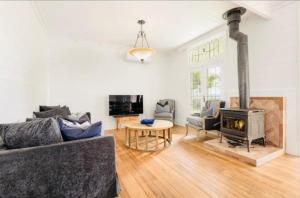 Una sala de estar con un sofá y una chimenea. en French Island Hill House, 