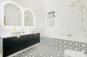 Un baño blanco con dos lavabos y una bañera. en French Island Hill House,  19 fotos más