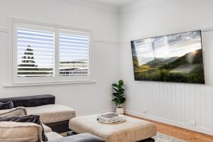 ein Wohnzimmer mit einer Couch und einem Fenster in der Unterkunft Botanic Breeze! Opposite Queens Park! in Toowoomba + 24 Fotos