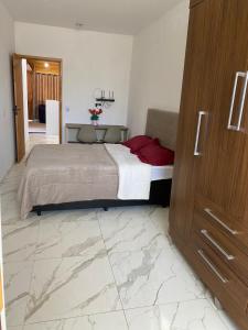 a bedroom with a large bed and a wooden cabinet at Kitnet Centro da Cidade in São Bento do Sapucaí