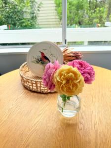 um vaso de flores sentado numa mesa em Renovated Entire 2BR Flat, Comfort, Scenic Views, Free Parking & 10 min to Ferry em Wellington