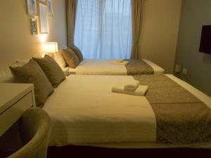 a hotel room with two beds and a window at OUCHI HOTEL Hiroshima Station in Hiroshima +84 photos