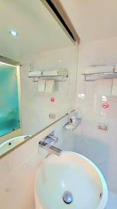 ein Badezimmer mit Waschbecken und Spiegel in der Unterkunft Bhanwar Pattaya Park Hotel in Pattaya South + 32 Fotos