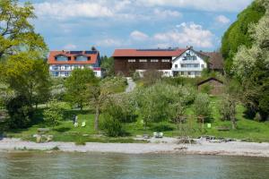 a group of buildings next to a river at Baumanns Ferienhof Am See in Bettnau