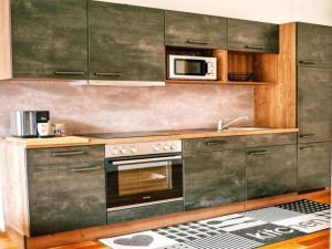 eine Küche mit Herd und Mikrowelle in der Unterkunft Bösenstein in Hohentauern + 17 Fotos