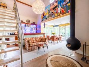 a living room with a couch and a spiral staircase at Wellnesshuisje Kalheupink in Oldenzaal