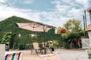a table and chairs under an umbrella on a patio at Pousada do Mestre in Pontal do Paraná