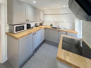 a kitchen with white cabinets and a microwave at The Merchants Penthouse - Uk50408 in Canterbury +1 photo