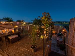 eine Terrasse mit Bank und Tisch auf einem Dach in der Unterkunft Harpers Cottage in Barrowford