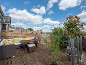 eine Terrasse mit einem Sofa und einem Tisch auf einer Terrasse in der Unterkunft Harpers Cottage in Barrowford