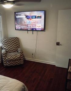ein Zimmer mit einem Stuhl und einem Flachbildfernseher in der Unterkunft Piedmonts Escape in Atlanta