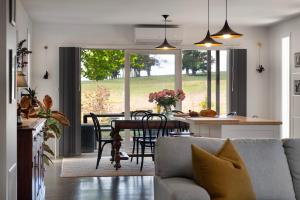 a living room with a couch and a table with chairs at Wayward Cottage in Daylesford