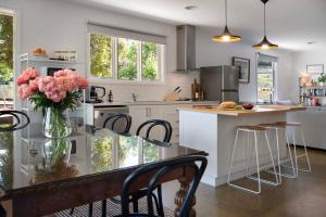 a kitchen with a table with a vase of pink flowers at Wayward Cottage in Daylesford +8 photos