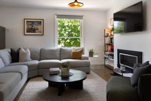 a living room with a couch and a table at Wayward Cottage in Daylesford