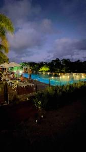 a large swimming pool at night with lights at Refúgio VIP Pé na Areia no Campeche - Piscina, Sauna e Academia até 08 pessoas in Florianópolis