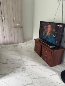 einen Flachbild-TV auf einer Kommode in einem Schlafzimmer in der Unterkunft Emi House in Acacías