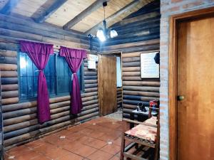 a room with wooden walls and a window with purple curtains at Campo Los Teritos in Abasto +7 photos