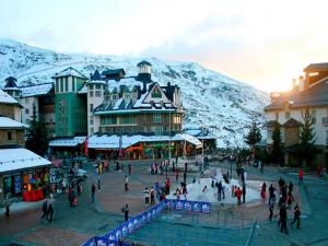 a group of people walking around a town in the snow at Ski Apartment in Sierra Nevada in Sierra Nevada
