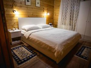 a bedroom with a large bed with a wooden wall at Four bedroom villa in Vukovar +17 photos