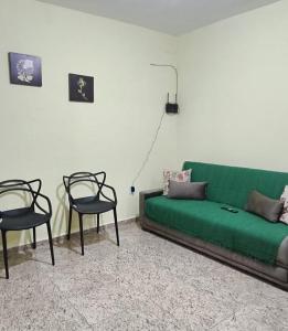 - un salon avec un canapé vert et 2 chaises dans l'établissement Casa de praia Região dos Lagos - CASA VERDE - Unamar - Cabo Frio RJ, à Cabo Frio