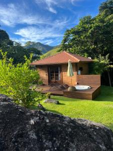 une maison avec une terrasse avec un jacuzzi dans l'établissement Cactus Chalés & Cabanas em lumiar, à Lumiar