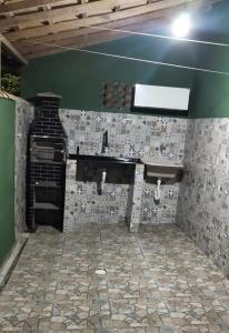 une cuisine avec un évier et un sol en pierre dans l'établissement Casa de praia Região dos Lagos - CASA VERDE - Unamar - Cabo Frio RJ, à Cabo Frio