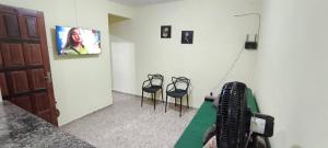Cette chambre dispose de 2 chaises et d'une télévision murale. dans l'établissement Casa de praia Região dos Lagos - CASA VERDE - Unamar - Cabo Frio RJ, à Cabo Frio 25 autres photos