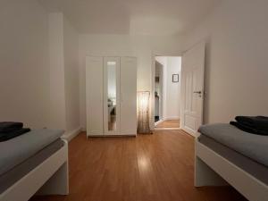 BremerhavenLuxus Apartment im Goetheviertel mit Badewanne, Regendusche WLAN uvm的一间空房,配有两张床和镜子